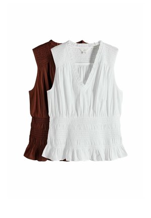 Two sleeveless tops with smocked details and ruffled hems, one white with a V-neck front and one brown with a round neckline.
