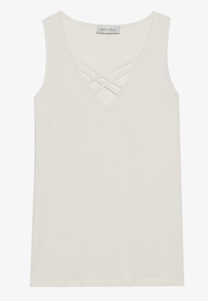 Top senza maniche color crema con scollatura profonda a V e dettagli a incrocio sulle spalle. Realizzato in tessuto morbido con una texture liscia, senza decorazioni.