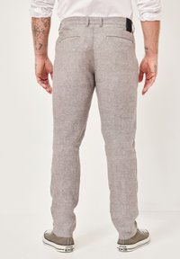Men's gray linen blend trousers with a straight cut, two back pockets, and subtle textured fabric. Worn with gray sneakers.