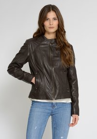 Mörkbrun läderjacka med ståkrage, dragkedja och sömnadsdetaljer. Har sidofickor och en figursydd silhuett.