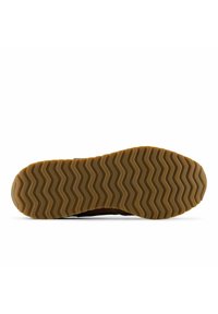 Shoe sole with brown rubber tread featuring wavy zigzag pattern and repeated "new balance" text across the outsole.
