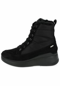 Botas negras hasta el tobillo con parte superior de ante y nylon acolchado, con forro de piel sintética, punta redonda y suela de goma texturizada. Cierre con cordones en la parte frontal.
