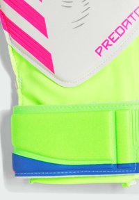 Guantes de portero en un brillante verde neón con acentos en rosa y blanco. Presentan una superficie de agarre texturizada y una correa para la muñeca segura en azul.