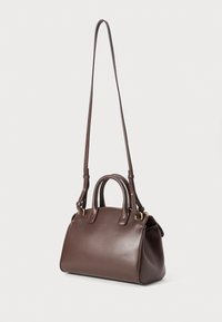 Sac à main en cuir brun avec une texture lisse, équipé de doubles poignées et d'une longue sangle réglable, avec des accents en métal doré.