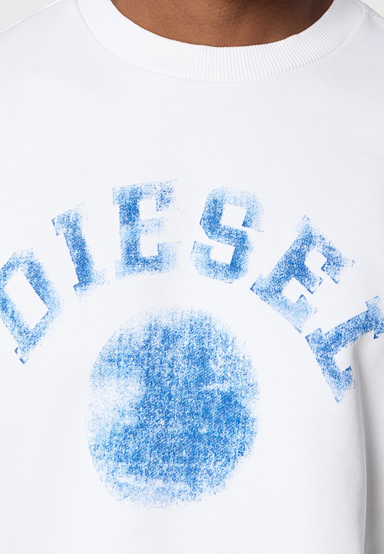 Felpa bianca con una grafica circolare blu sbiadita, con la parola "DIESEL" in carattere corsivo, audace e testurizzato che si incurva sopra il design.