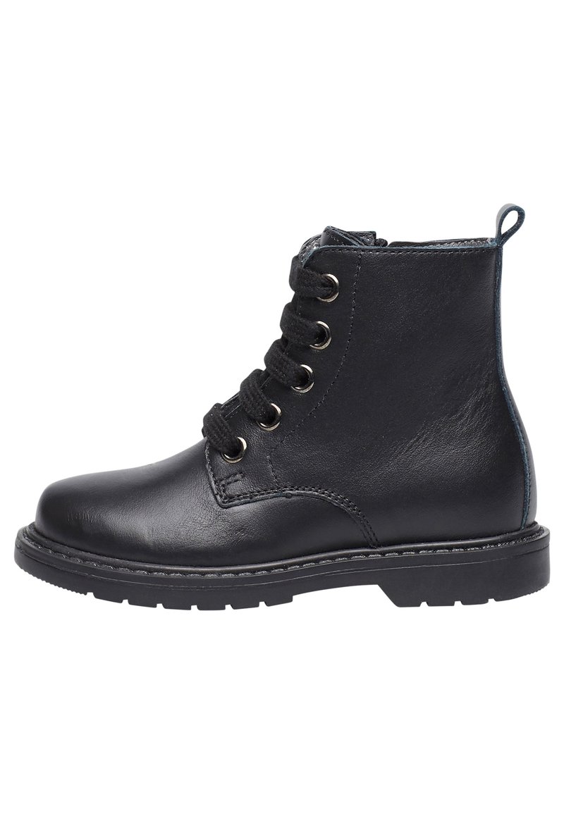 Zwarte leren enkellaars met zes metalen oogjes, zwarte veters, versterkte neus en gestructureerde zool. Heeft een klein lusje bij de hiel.