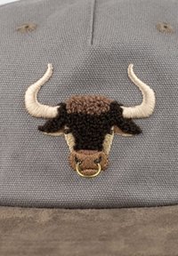 Gray cap featuring a textured embroidered bull head design in brown and cream, with a gold ring accent on the snout.