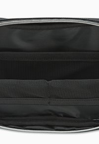 Borsa con zip nera dal design esterno in tessuto liscio. L'interno presenta tasche in rete e un rivestimento testurizzato per una migliore organizzazione.