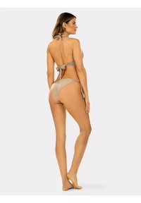 Beżowy bikini z dekoltem na sznurku i kokardką, charakteryzujące się gładką teksturą i minimalnym zakryciem na dole. Design podkreśla smukłą sylwetkę.