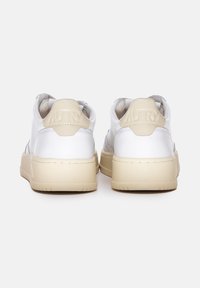 Sneaker bianche in pelle con suola in gomma beige, dotate di colletto imbottito e linguetta sul tallone posteriore con il logo "AUTRY" impresso. Texture liscia e design semplice.
