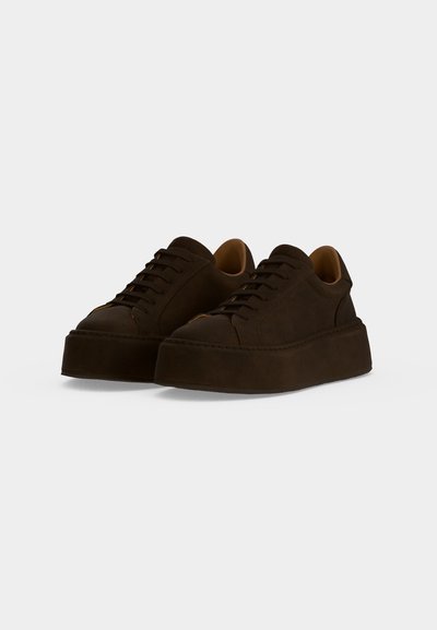 Ζευγάρι σκούρα καφέ πλατφόρμα sneakers με δέσιμο και χοντρή σόλα, απεικονισμένα σε λευκό φόντο.