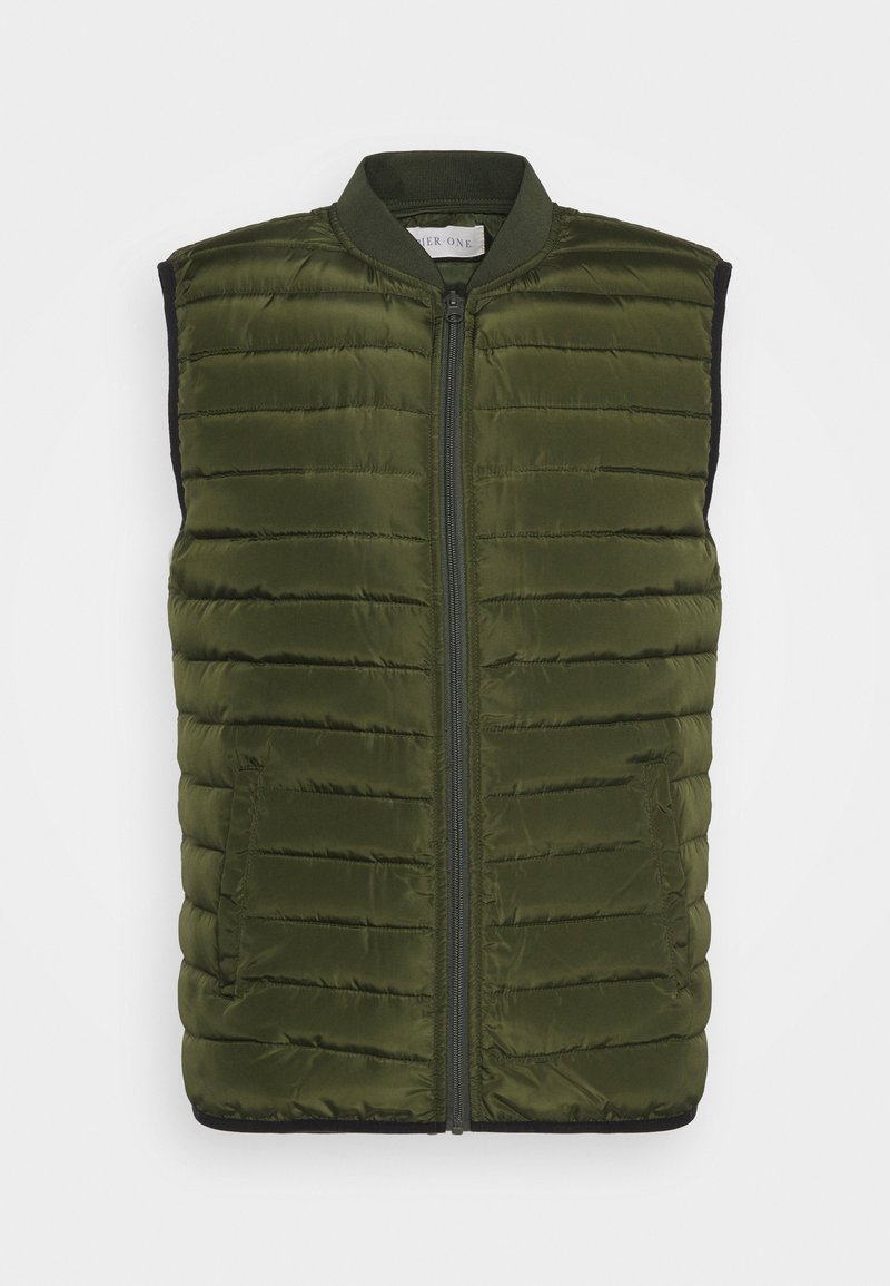 Veste matelassée sans manches verte avec fermeture éclair à l’avant et col côtelé, présentée sur fond uni.
