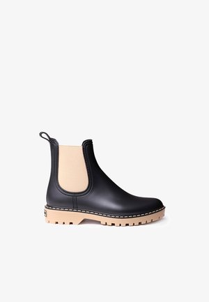 Czarne gumowe botki Chelsea z elastycznymi beżowymi panelami bocznymi, masywną beżową podeszwą oraz pętelką z tyłu ułatwiającą zakładanie.