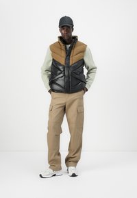 Helly Hansen VILLAGE PUFFY VEST UNISEX - Liemenė - sepia