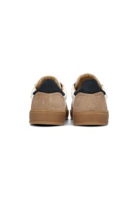 Zapatillas marrones y blancas con un upper de ante y cuero, suela de goma y un acento textil negro en el talón.