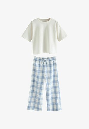 Balta trumpomis rankovėmis trumpa marškinėliai derinami su šviesiai mėlynais ir baltais languotais, plačiomis kojomis kelnėmis, turinčiomis elastingą juosmenį ir raištelį.