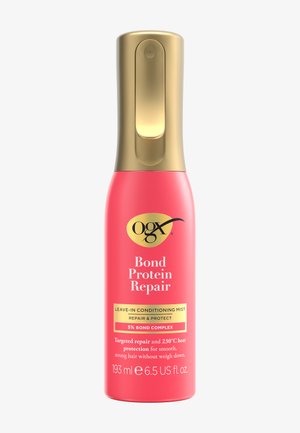 Flacone spray rosa e oro etichettato OGX Bond Protein Repair leave-in conditioning mist per riparazione dei capelli e protezione dal calore, 193 ml.