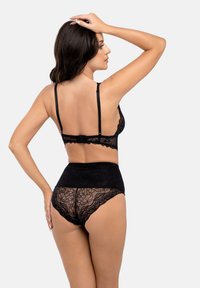 Svart spetsunderkläder set med en bralette med låg rygg och högmidjade trosor med intrikata blommönster och vågiga kanter.