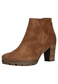 Bottine en daim marron avec un talon haut empilé, un bout arrondi et une semelle plateforme texturée. Design élégant avec des détails de couture minimalistes.