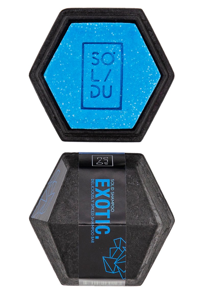 Savon solide en forme hexagonale, avec un dessus bleu parsemé et une base noire, étiqueté "EXOTIC" en bleu sur un emballage noir.