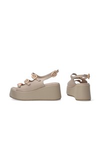 Beige platform sandalen met drie verstelbare banden met ronde gespaccenten, open teen ontwerp en textuur gevoerde wedge zool.