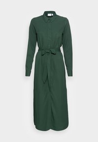 Grön klänning med långa ärmar gjord av ett slätt tyg, med krage, knappstängning, bälte i midjan och sidoklaffar.