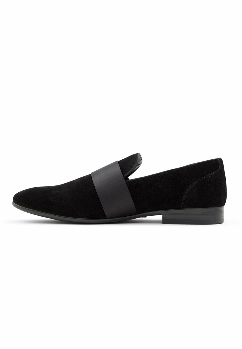 Black suede slip-on shoe featuring a wide satin band across the upper, rounded toe, and a low, textured heel for stability.