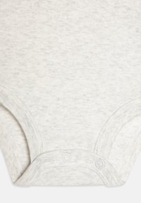 Šviesiai pilkas medvilninis šortų rankovių bodžiukas, pasižymintis minkšta tekstūra, snapeliais apačioje ir švariu, paprastu dizainu.