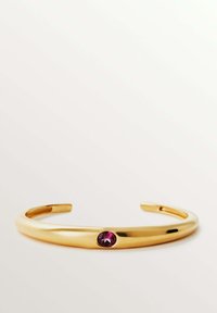 Pulsera de muñeca en tono dorado con un acabado suave y pulido, y un acento de gema redonda de color púrpura. Diseño simple y abierto para un uso fácil.