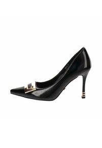 Zapato de charol negro con tacón alto y punta afilada, detalle de hebilla dorada en la parte delantera y tacón delgado con anillos dorados cerca de la base.