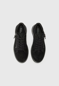 Black suede sneakers with a textured finish, featuring laces and a side zipper, rounded toe, and a contrasting rubber sole.