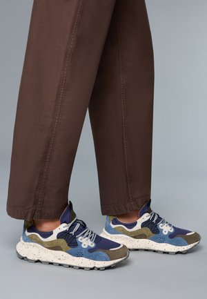 Sneaker multicolori con una combinazione di blu navy, blu, oliva e una suola maculata bianca. Presentano materiali in suede sovrapposti, mesh e un design con lacci.