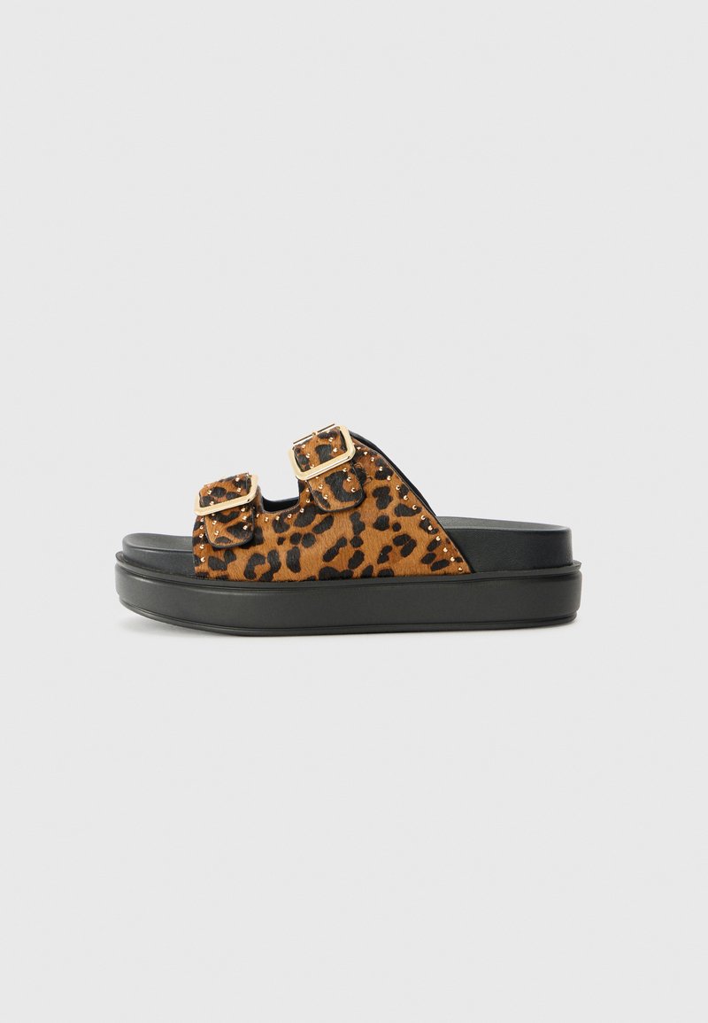 Leopard print slide sandals with two adjustable gold buckles, black rubber sole, and a textured brown upper.