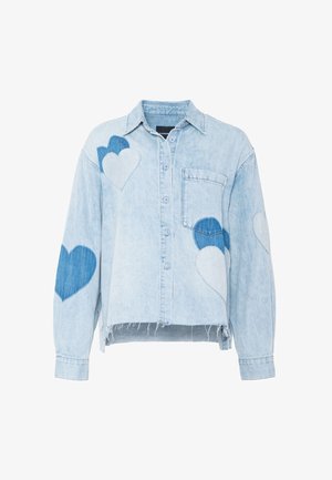 Lyseblå denimjakke med knapper, dekorert med blå og hvite hjerteflekker og en frynsete kant, med brystlomme og krage.