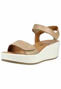 Sandale compensée en cuir beige avec brides réglables à la cheville et aux orteils, semelle plateforme blanche, et détail logo doré sur la bride avant.