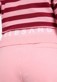 Pink cotton sweatpants with an elastic waistband displaying "ELBSAND" in white. The top features maroon and light pink horizontal stripes.