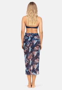 Lekka, przezroczysta długa spódnica w ciemnoniebieskim kolorze z różowym i turkusowym wzorem w kwiaty, z falbaniastym dołem i regulowanym paskiem w talii.