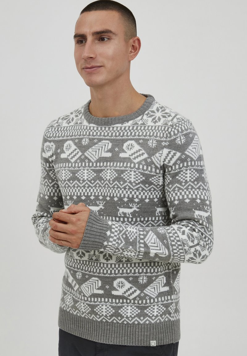 Grå strikket sweater med indviklede hvide geometriske og snefnugs mønstre, ribbede manchetter og rund hals.