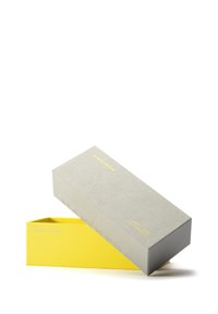 Pikslik hall kast, millel on kollane tekst, osaliselt avatud, et näidata eredat kollast sisu ja lauset "Valmistatud taaskasutatud materjalidest."