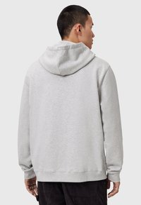 Felpa grigia con cappuccio, dal fit rilassato, con maniche lunghe e una texture morbida. Sul retro presenta un design semplice senza decorazioni.
