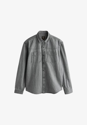 Pelēkā džinsa garām piedurknēm krekls, pogu aizdare priekšā, divi krūšu kabatas, norādīta apkakle un izšuvumi gar šuvēm un pleciem.