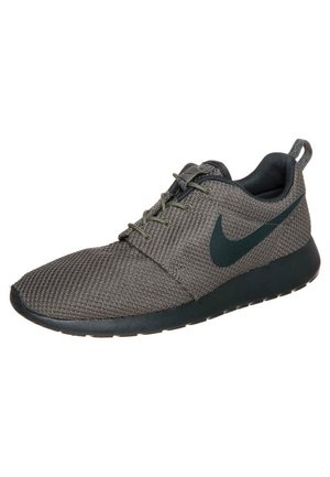 Męski ciemnoszary but do biegania Nike z czarną podeszwą, materiałem siateczkowym, sznurówkami i czarnym logiem Nike Swoosh po boku.