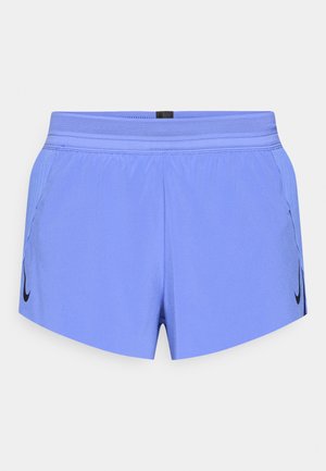 Pantalones cortos deportivos de color púrpura claro con cinturilla de malla, bolsillos laterales y un logo negro de Nike en el lado izquierdo. Material suave y ligero.