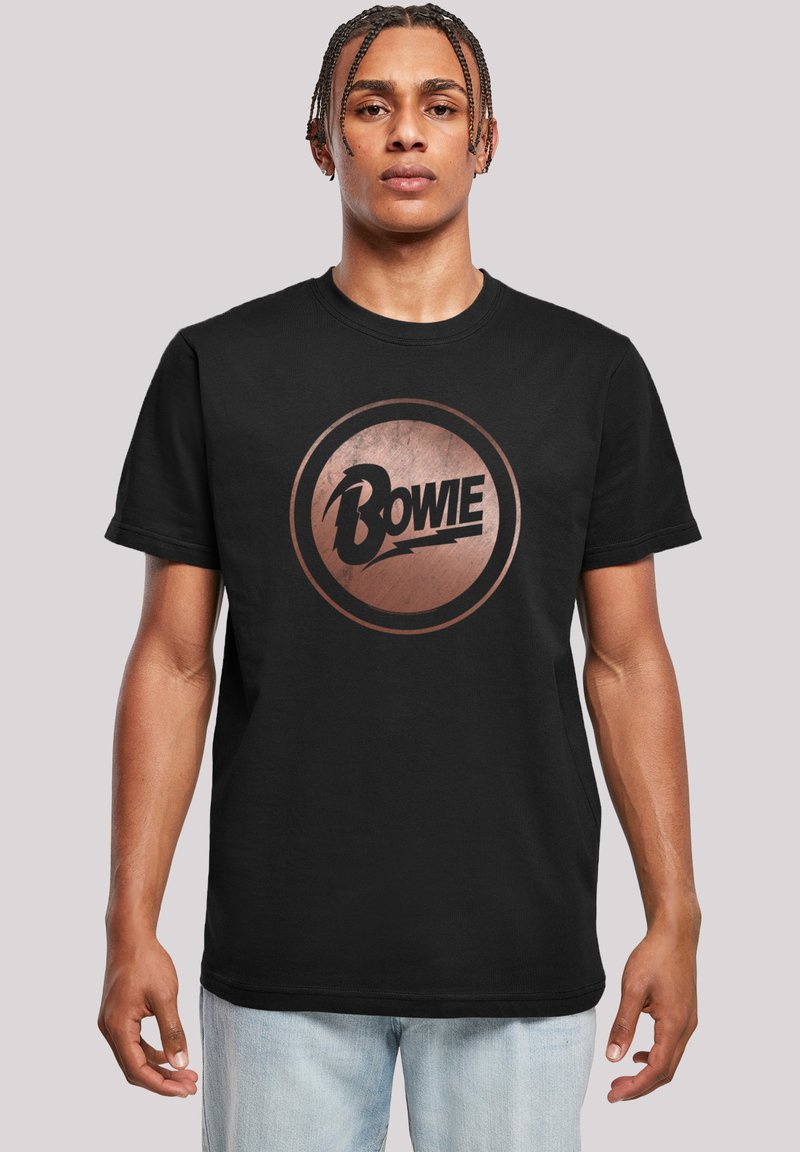 Schwarzes Baumwoll-T-Shirt mit einem kreisförmigen Grafikdesign, das einen bronzenen und schwarzen Blitz zeigt, sowie dem Text "Bowie" in fetter Schrift.