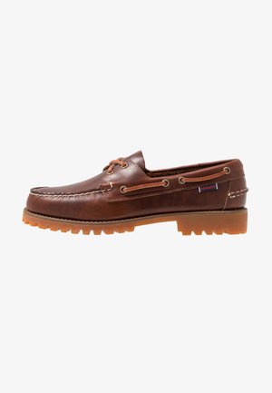 Braune Lederbootsschuh mit Gummi-Außensohle, Schnürlöchern und gesticktem Obermaterial, das ein erhabenes, strukturiertes Muster entlang der Zehenpartie aufweist.