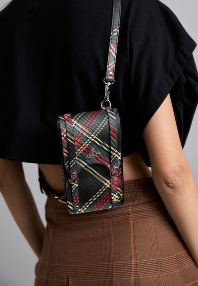Sac en bandoulière à carreaux noirs avec des accents rouges, verts et jaunes, une texture lisse, une bandoulière ajustable et des détails en métal.