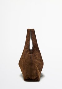Bruine suède tas met een afgeronde bodem en een open bovenkant. Voorzien van twee verlengde handvatten en zichtbare contrasterende stiksels aan de zijkanten.