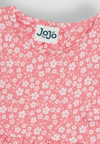 Roosa puuvillane kleit lillemustriga, millel on valged lilled tekstureeritud taustal ja ümmargune kaelus. Silt kannab kirja "JoJo."