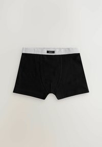 Boxer da uomo neri con una cintura elastica grigia con il nome del marchio "NEXT." Tessuto liscio con un design aderente.