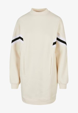 Hanorac crem cu guler înalt, mâneci lungi și două buzunare laterale. Prezintă dungi negre și albe pe umeri. Material moale, texturat.